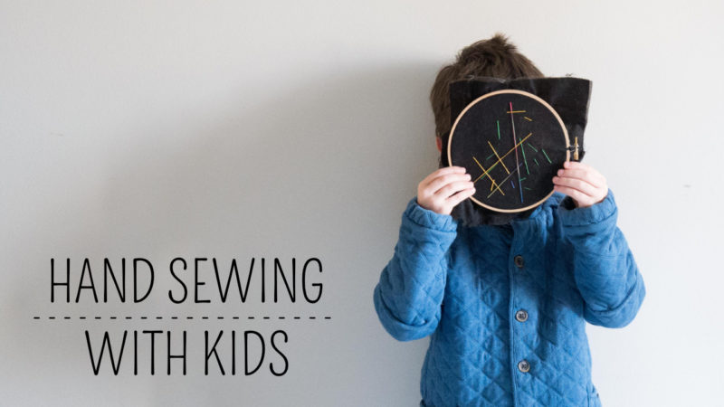 boy holding embroidery hoop over face