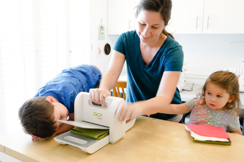 mom and kids using fabric cutter