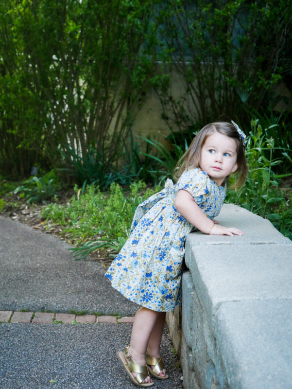 baby girl leaning over bridge