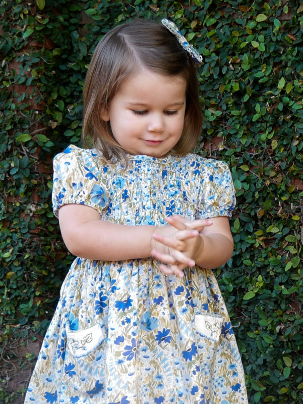 girl wearing floral dress by ivy wall