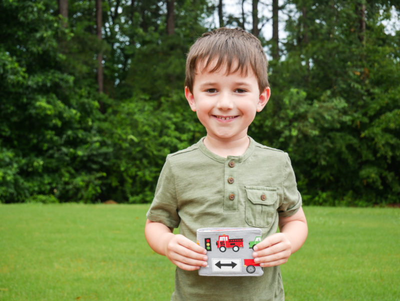 boy holding closed wallet he made with trucks 