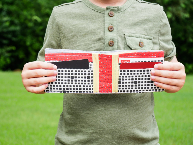 boy holding open wallet he made with trucks 